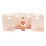 four custom paper bags with round die-cut handles and a bottle of drink in the middle of them