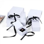 a bunch of white custom wholesale ribbon closure boxes in different sizes