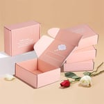 a bunch of custom tuck-top mailer carton boxes and there are two roses beside